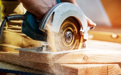 New home constructiion project building contractor worker using hand held worm drive circular saw to cut boards